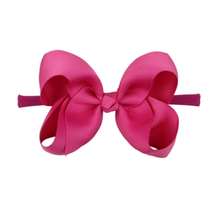 Detail view of soft pink candy-colored nylon headband with a bow for babies