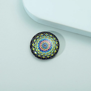 Macro detail of round crystal glass fridge magnet with colorful mandala floral pattern