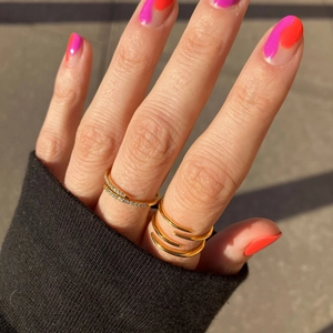 Detail of 18K gold-plated stainless steel layered rings with crystals on a model's hand