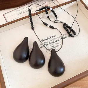 Vintage dark wood gourd teardrop necklace and earring set with black beaded cord
