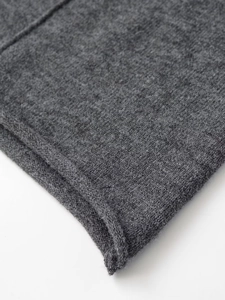 Detailed close-up of dark grey ribbed knit fabric texture and rolled hem edge