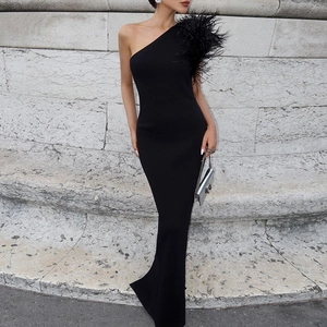 Detail of elegant black one-shoulder evening gown with premium feather trim on shoulder