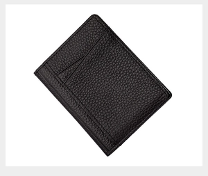 Detail of slim black lychee grain leather card holder showing textured surface and slots