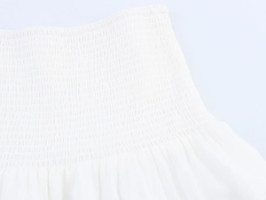 Detailed view of elastic smocking craft on white chiffon bohemian beach style dress