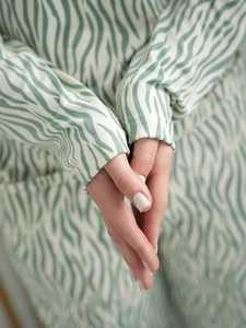 Close-up of green and cream zebra print pajamas showing the soft fabric and cuff details