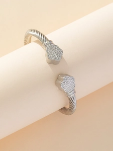 Dettaglio macro del bracciale ritorto in acciaio inossidabile con estremità a trifoglio