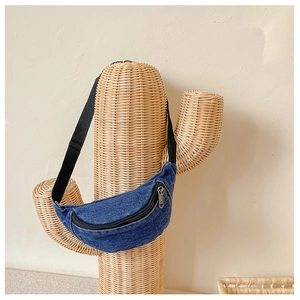 Detail of blue denim waist bag with silver zipper on a creative cactus stand