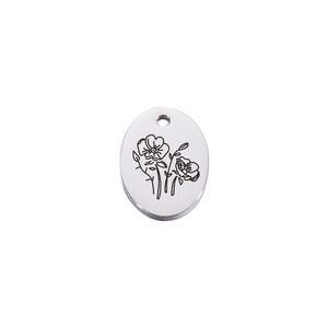 Macro view of oval silver stainless steel pendant with delicate floral line engraving