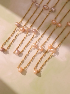 Detailed macro view of gold chain with irregular colorful natural freshwater pearls