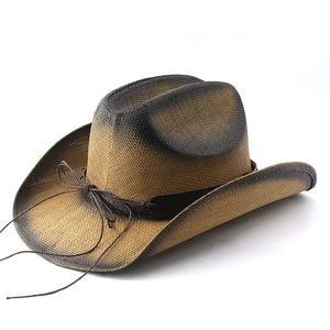 Détail du chapeau de cowboy en paille tressée avec dégradé marron et ruban en cuir