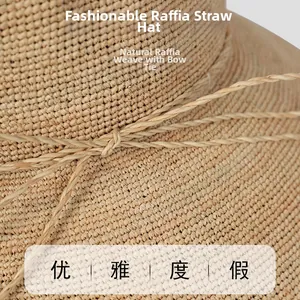 Detail of natural raffia straw hat showing hand-woven texture and delicate bow tie ribbon