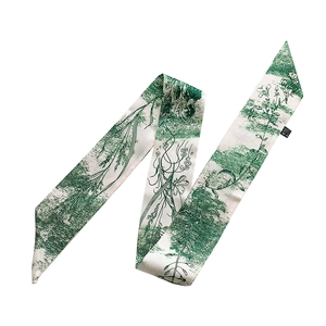 Detail of white silk scarf with green floral print and hand-painted plant patterns