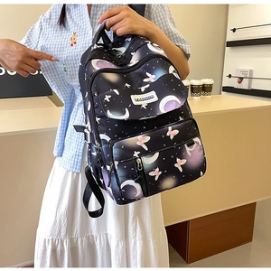 Detailed view of black starry sky backpack featuring colorful moon and butterfly patterns