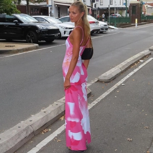 Detail of pink floral backless dress with side slit and slim fit silhouette