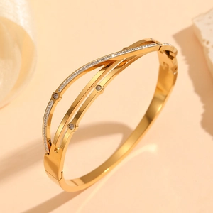 Macro detail of gold plated geometric bangle with sparkling white zircon stones