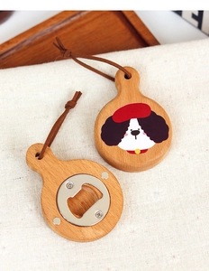 Détail d'un décapsuleur rond en bois avec motif chien et cordon en cuir attaché