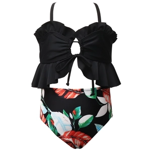 Détail du maillot deux pièces fille avec haut à volants noir et bas à imprimé tropical feuillage