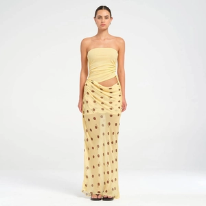 Détail d'un haut bustier jaune et d'une jupe longue en tulle à pois marrons