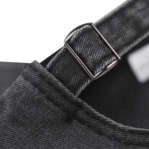 Detailed macro view of the washed black denim baseball cap with vintage metal buckle