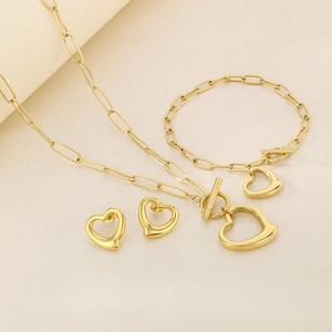 Detailed view of golden jewelry set featuring heart pendants and paperclip chains