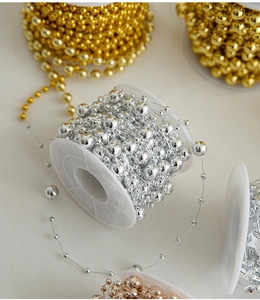Detail showing shiny gold and silver plated bead chains on white plastic spools for DIY decor
