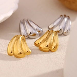 Elegant 18K gold and silver plated hollow ribbed hoop earrings for women on beige surface
