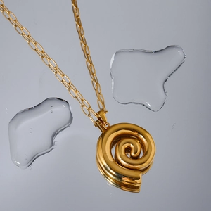 Close-up of 18k gold plated stainless steel spiral pendant on paperclip chain with water drops