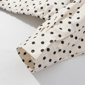 Detailansicht von cremefarbenem Polka-Dot-Stoff mit elastischem Kordelzug und feinen Nähten