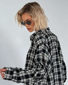 Detail view of the black and white plaid fabric texture and oversize sleeve cuff