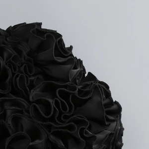 Détail du tissu en maille noire multicouche avec bords volantés sur l'ensemble de fête