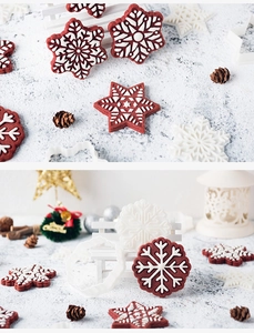Close-up of snowflake cookie cutters with red frosted biscuits on a festive wooden surface