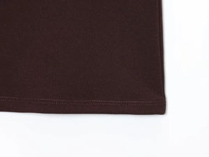 Macro detail of dark brown textile fabric with double-needle stitching on the bottom hem