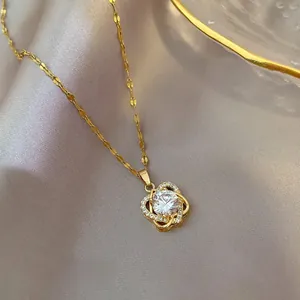 Macro shot of gold heart flower pendant with sparkling zircon and faceted metal chain