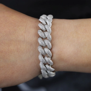 Close-up of a 15mm silver Cuban chain bracelet iced out with sparkling diamonds on a wrist