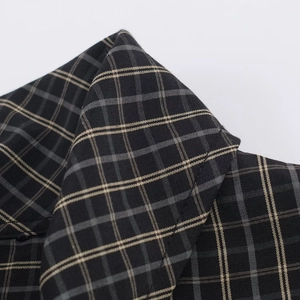 Close-up of black and khaki plaid shirt collar with precision stitching and woven texture