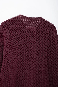Close-up of burgundy hollow out crochet knit sweater showing intricate mesh texture