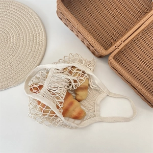 Close-up of cream woven mesh tote bag with cotton rope texture and hollow design