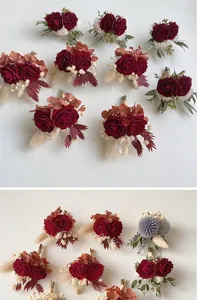 Close-up of deep red preserved rose boutonniere with white feathers and green berries