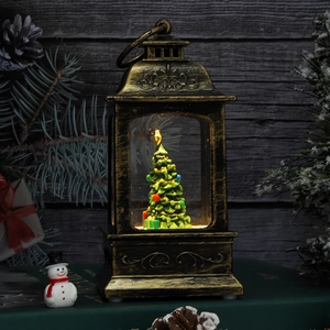 Detail of vintage Christmas lantern with green tree and festive bronze finish