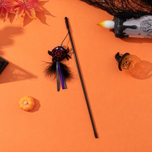 Halloween cat teaser wand with plush spider charm and feathers on orange background