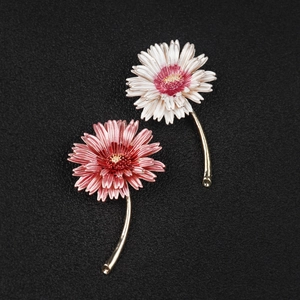 Detailed macro view of two colorful daisy pins with gold plating and fine floral texture