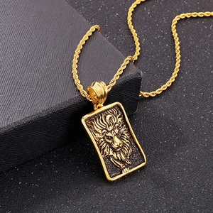 Détail d'un pendentif tête de lion doré avec une chaîne torsadée sur une boîte noire mat