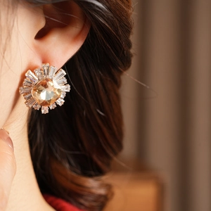 Macro shot of sunburst flower earring with amber zircon stone and radiant crystal petals