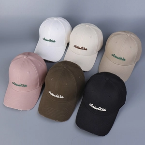 Detailed view of assorted cotton baseball caps with Achieve Wish embroidery and distressed brims