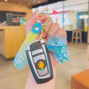 Astronaut liquid quicksand keychain with blue and yellow colors in hand-held view