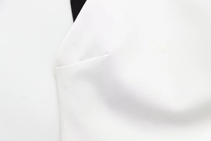 Detail of white fabric texture and black contrast trimming on this patchwork mini dress