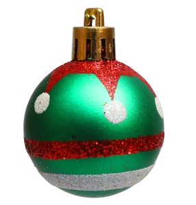 Macro shot of green Christmas ball with red and white glitter patterns on white background