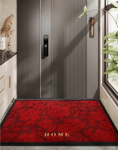 Detailaufnahme einer roten Blumen-Fußmatte mit goldenem HOME-Schriftzug und rutschfestem Rand