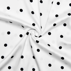 Close-up of white fabric with black polka dots showing smooth texture and spiral draping
