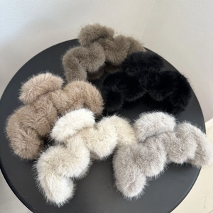 Top view of plush faux fur hair claws in dark brown, beige, black, and grey tones
